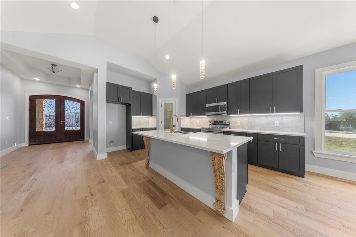 217 Gato Road Cedar Creek, TX 78612 - Photo 14 of 39 Kitchen with healthy amount of natural light, decorative light fixtures, decorative backsplash, lofted ceiling, and recessed lighting