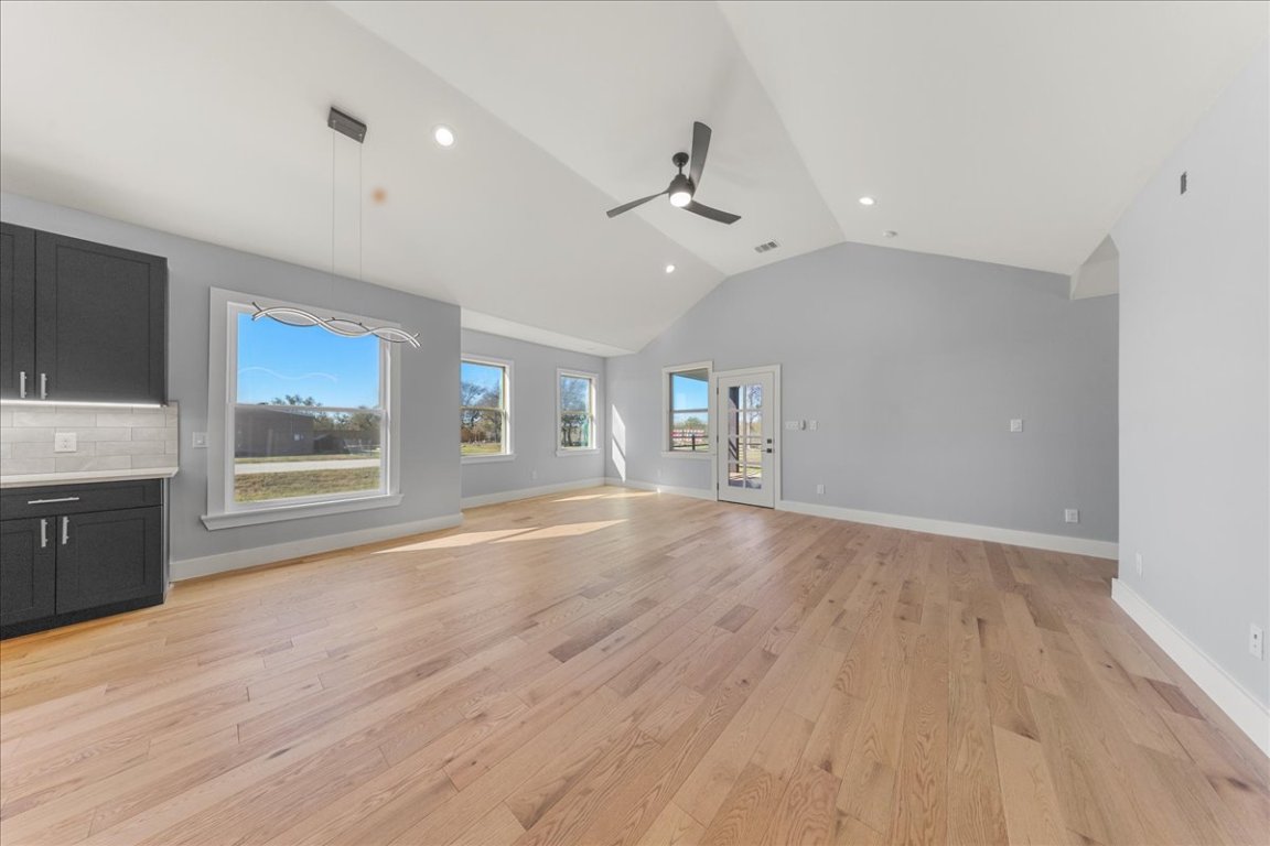 217 Gato Road Cedar Creek, TX 78612 - Photo 16 of 39 Unfurnished living room featuring lofted ceiling, light wood-style floors, recessed lighting, and ceiling fan