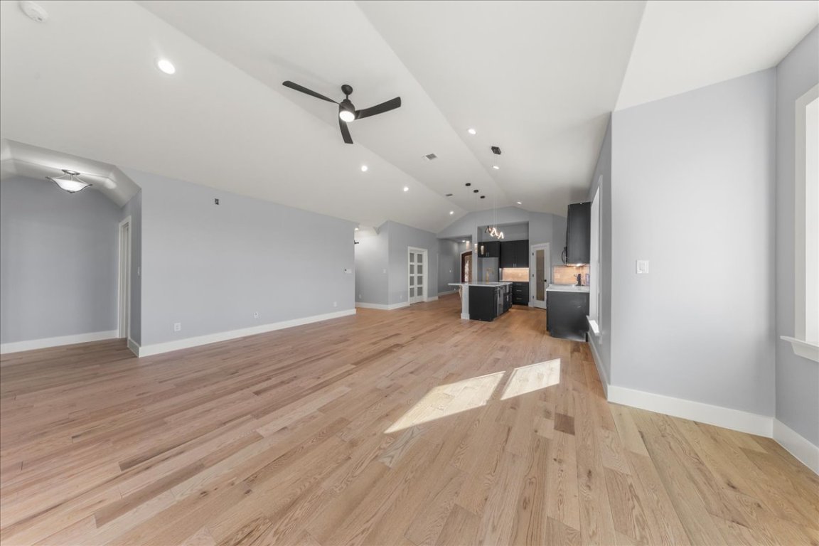 217 Gato Road Cedar Creek, TX 78612 - Photo 17 of 39 Unfurnished living room featuring vaulted ceiling, a ceiling fan, recessed lighting, and light wood-style flooring