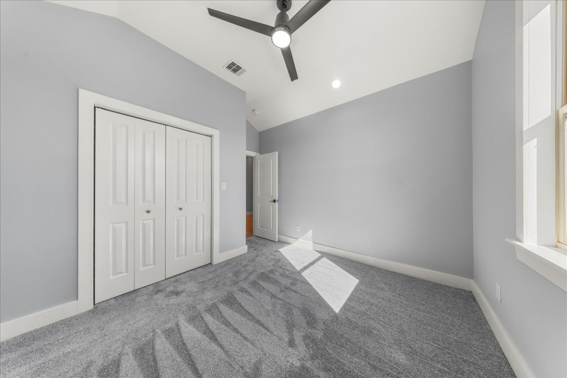217 Gato Road Cedar Creek, TX 78612 - Photo 22 of 39 Unfurnished bedroom with lofted ceiling, carpet, ceiling fan, a closet, and recessed lighting