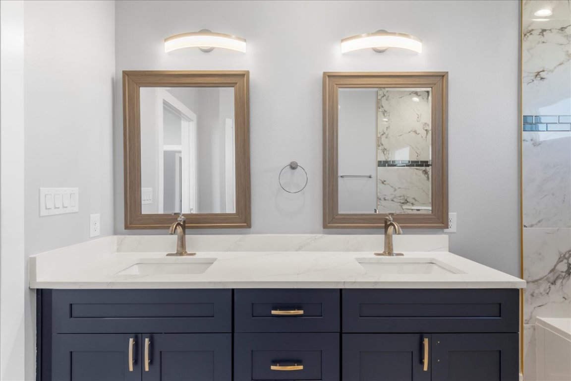 217 Gato Road Cedar Creek, TX 78612 - Photo 28 of 39 Full bath featuring double vanity, a bath, and a marble finish shower