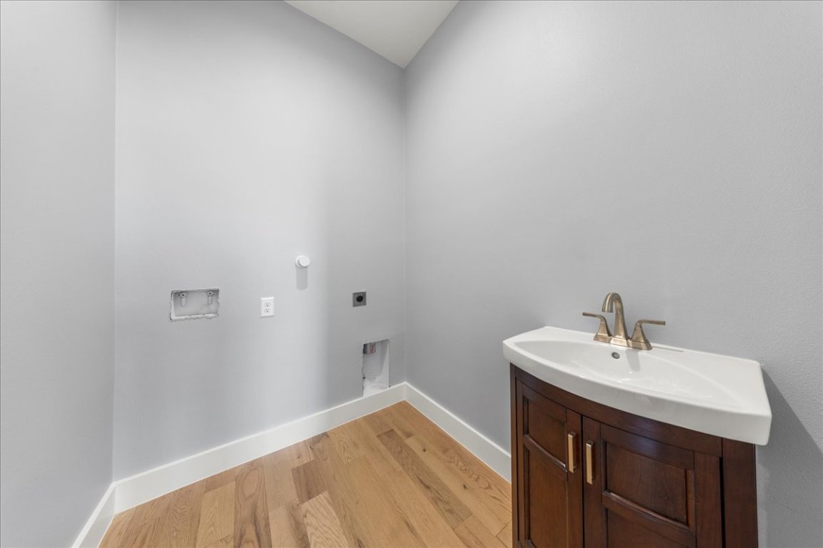 217 Gato Road Cedar Creek, TX 78612 - Photo 35 of 39 Washroom with light wood finished floors, electric dryer hookup, and hookup for a washing machine