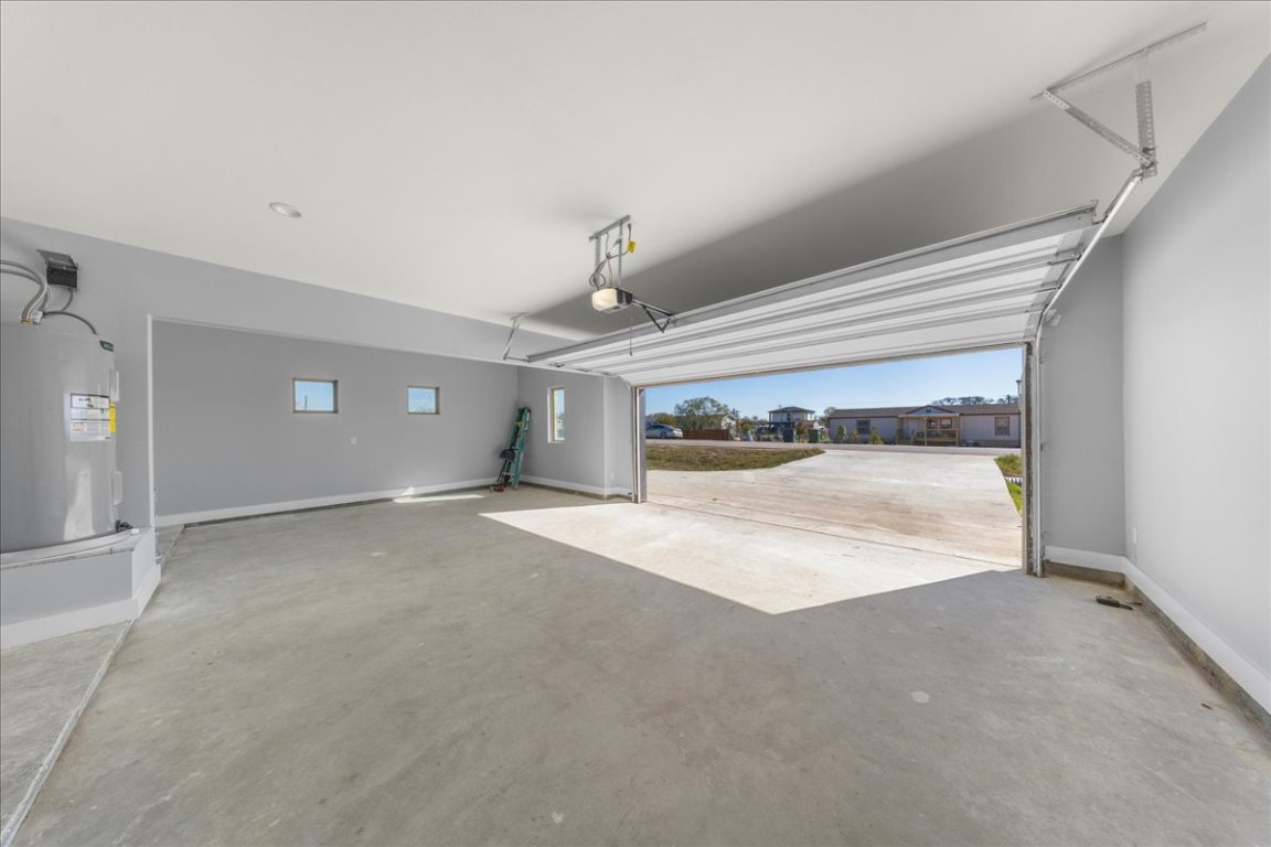 217 Gato Road Cedar Creek, TX 78612 - Photo 36 of 39 Garage featuring electric water heater and baseboards