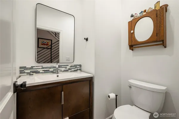 a bathroom with a toilet sink vanity and mirror