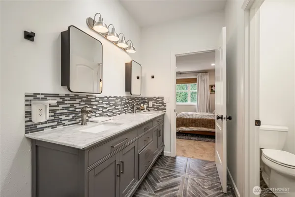 a bathroom with a sink and a mirror with toilet