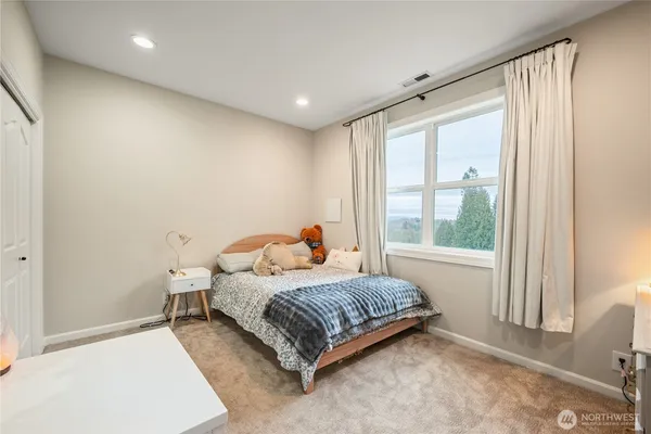 a bedroom with a bed and a large window