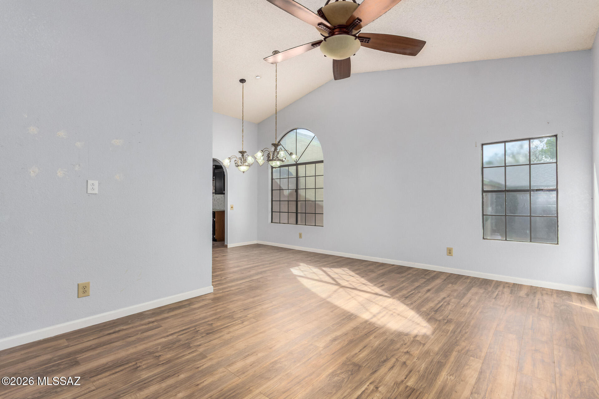 5331 West Eaglestone Loop Tucson, AZ 85742 - Photo 8 of 35 an empty room with wooden floor chandelier fan and windows