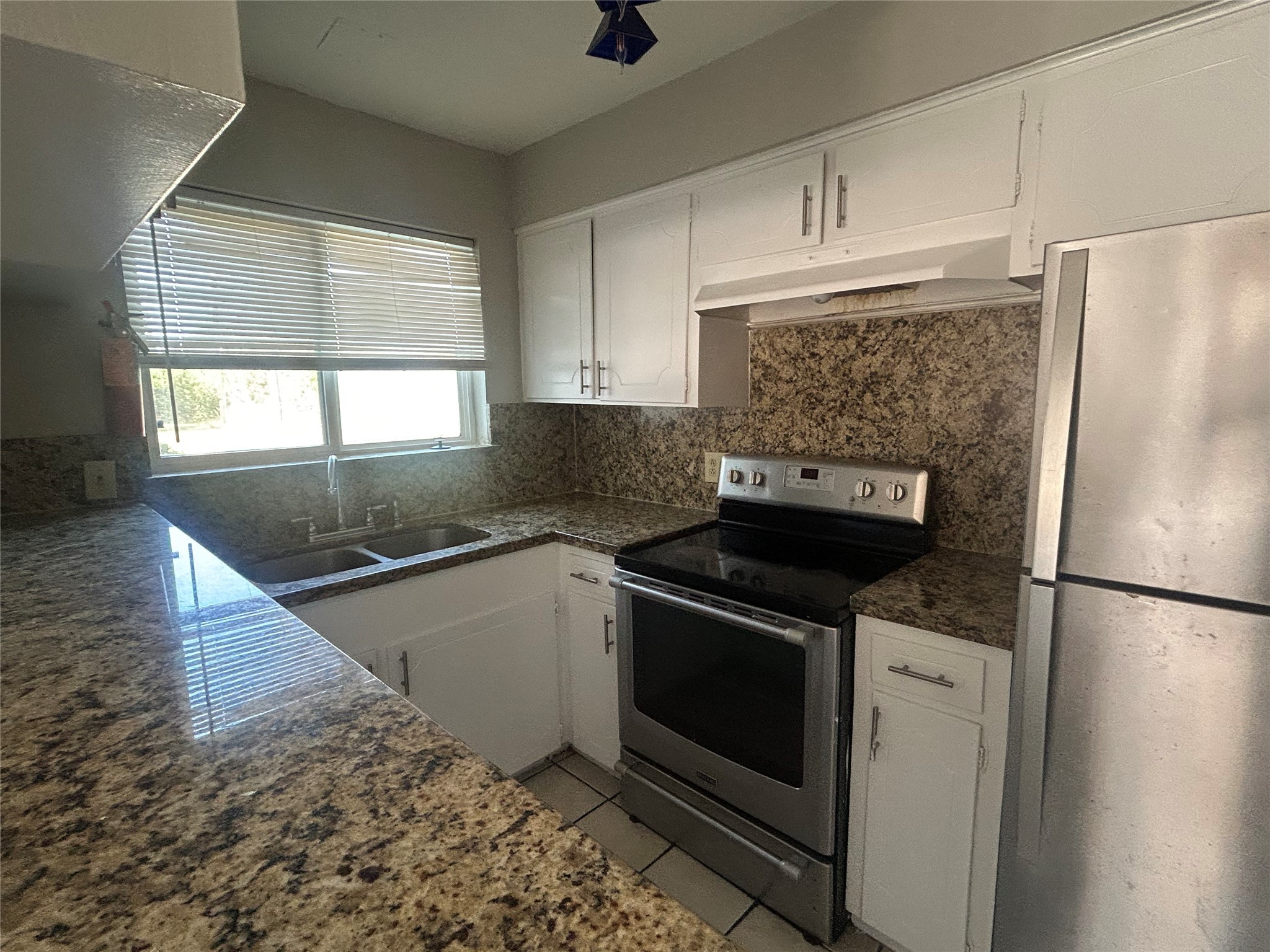 6702 Biggs Court, Unit 4 Houston, TX 77061 - Photo 2 of 6 a kitchen with granite countertop a refrigerator sink stove and cabinets
