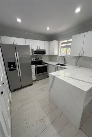 a kitchen with stainless steel appliances a refrigerator sink and stove