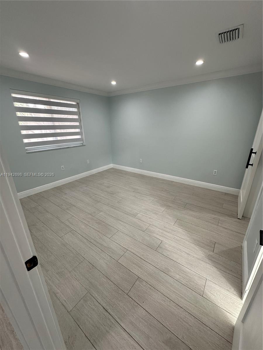 15250 Southwest 134th Place, Unit 112 Miami, FL 33177 - Photo 11 of 17 an empty room with wooden floor and windows