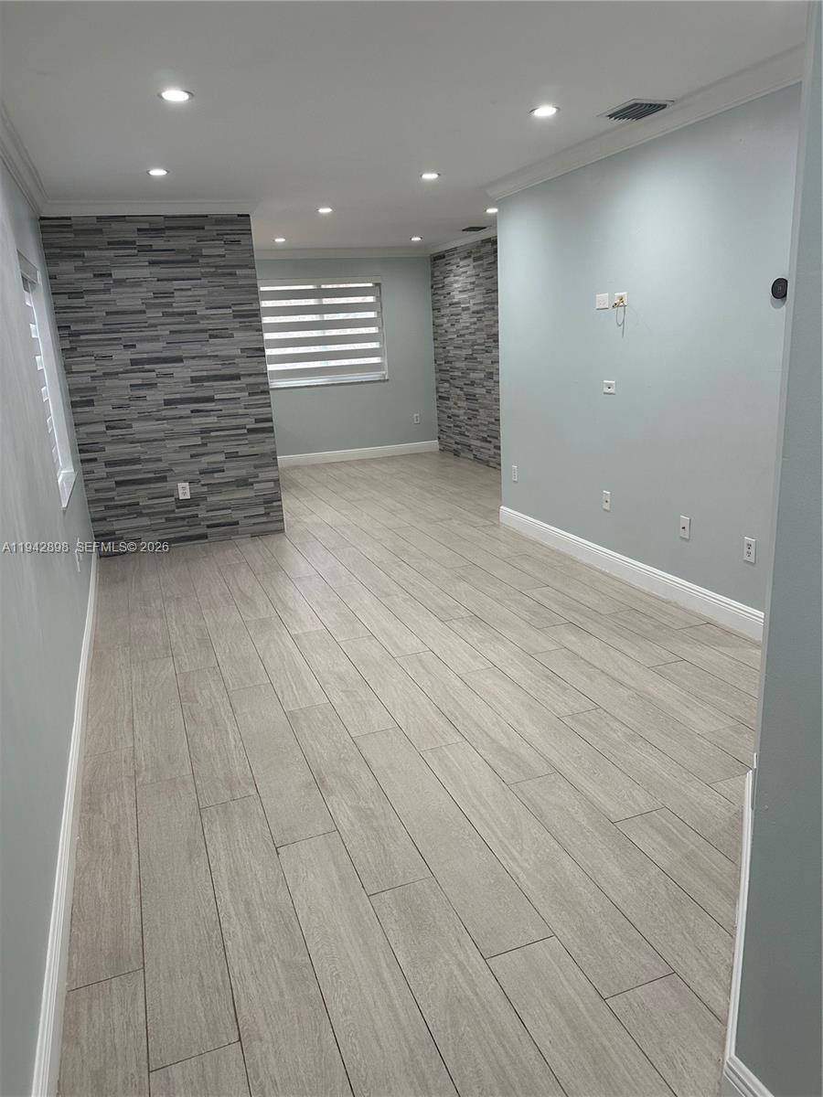 15250 Southwest 134th Place, Unit 112 Miami, FL 33177 - Photo 3 of 17 an empty room with wooden floor and windows