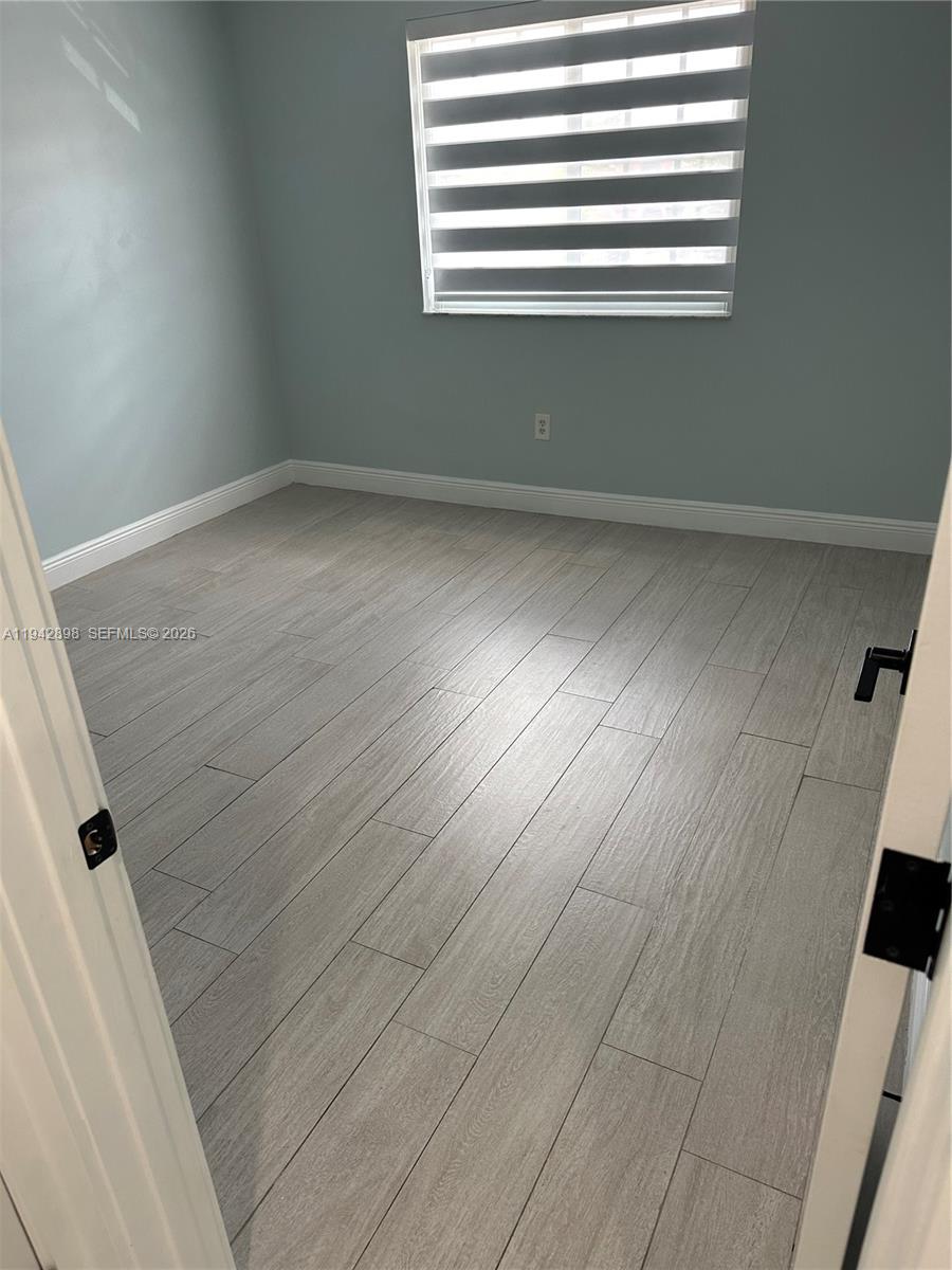 15250 Southwest 134th Place, Unit 112 Miami, FL 33177 - Photo 6 of 17 a view of empty room with wooden floor and fan