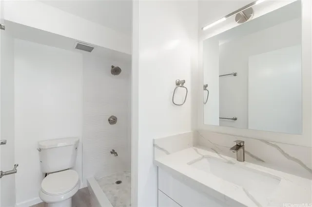 a bathroom with a granite countertop sink toilet and shower