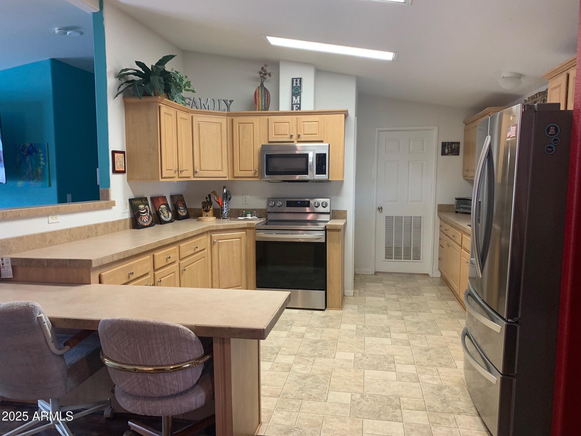 1231 West Roundup Street Apache Junction, AZ 85120 - Photo 6 of 30 a kitchen with a sink cabinets and stainless steel appliances