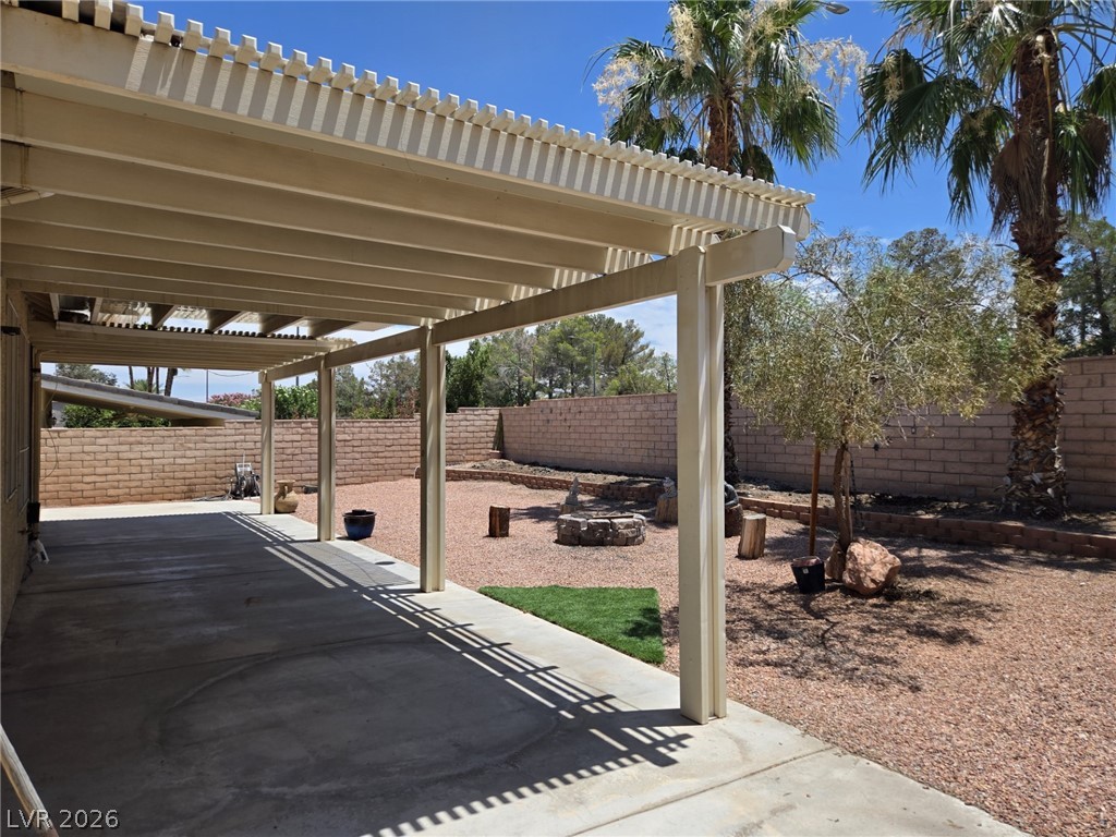 8417 San Ramon Drive Las Vegas, NV 89147 - Photo 30 of 33 A spacious covered patio invites outdoor enjoyment, overlooking a low-maintenance desert landscape with a built-in fire pit.