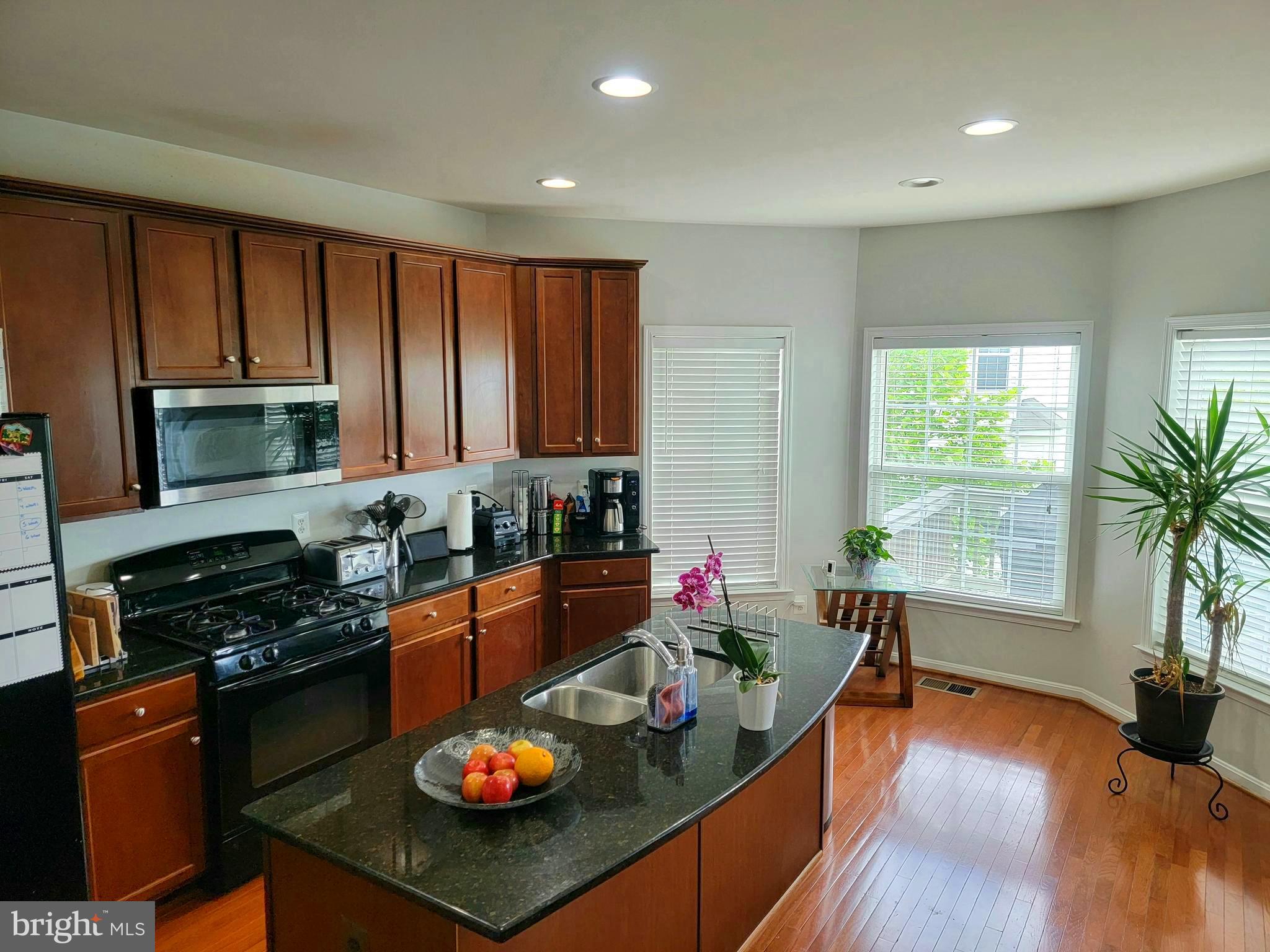 22573 Highcroft Terrace Brambleton, VA 20148 - Photo 4 of 13 a kitchen with stainless steel appliances granite countertop sink stove and cabinets