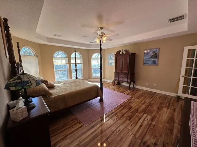 a bedroom with a bed dresser and a large mirror next to a window
