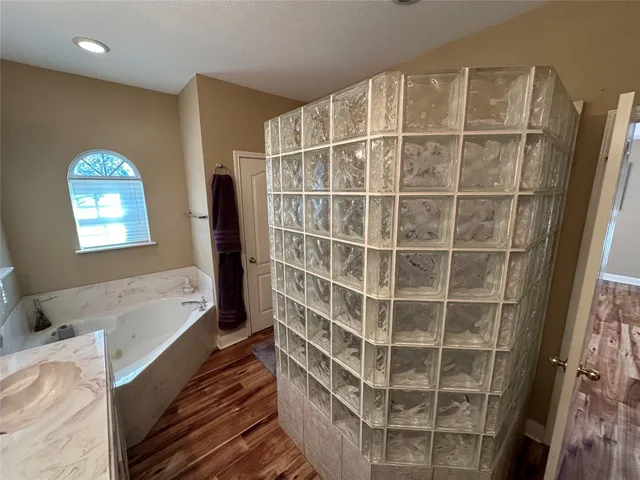 a bathroom with a tub and a large window