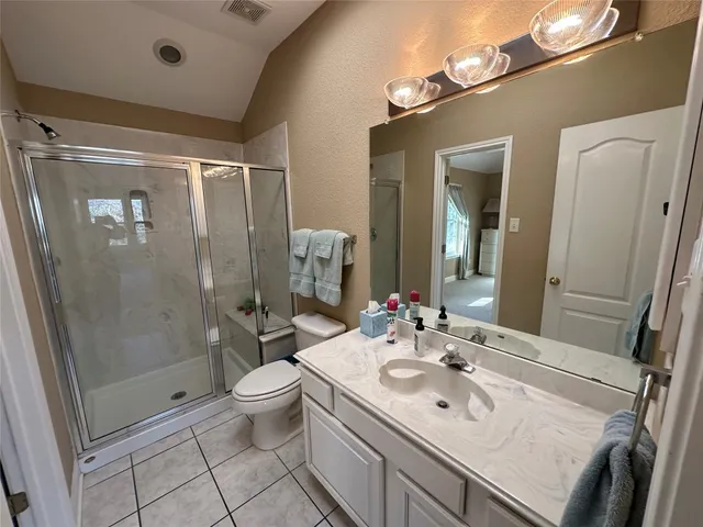 a bathroom with a sink a toilet a mirror and shower