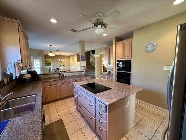 a kitchen with stainless steel appliances granite countertop a sink and a refrigerator