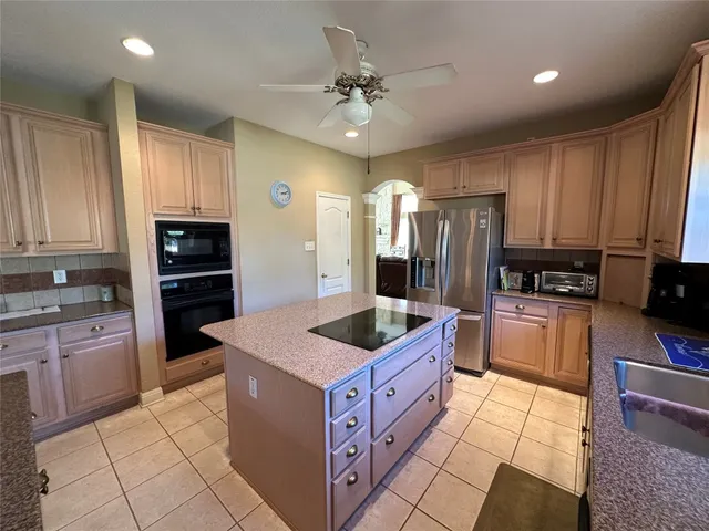 a kitchen with stainless steel appliances granite countertop a stove a sink and a refrigerator
