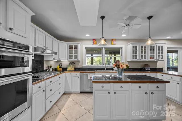 a kitchen with granite countertop white cabinets stainless steel appliances and a sink