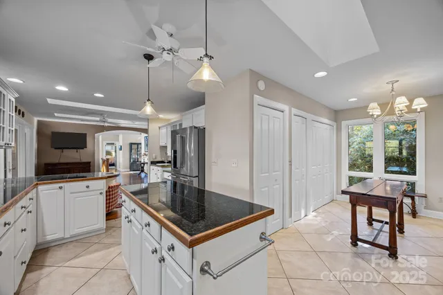a kitchen with stainless steel appliances granite countertop a stove a refrigerator and a dining table with wooden floor