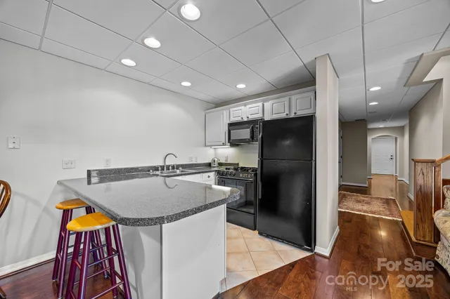 a living room with stainless steel appliances furniture and a large window