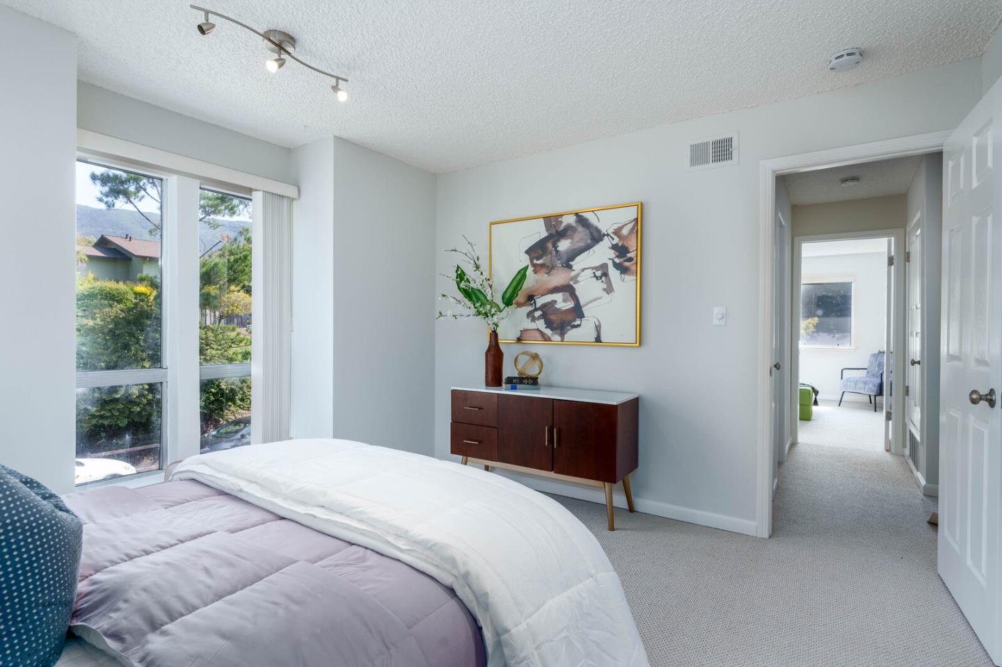 1021 Oddstad Boulevard Pacifica, CA 94044 - Photo 10 of 15 a bedroom with a bed and a painting on the wall