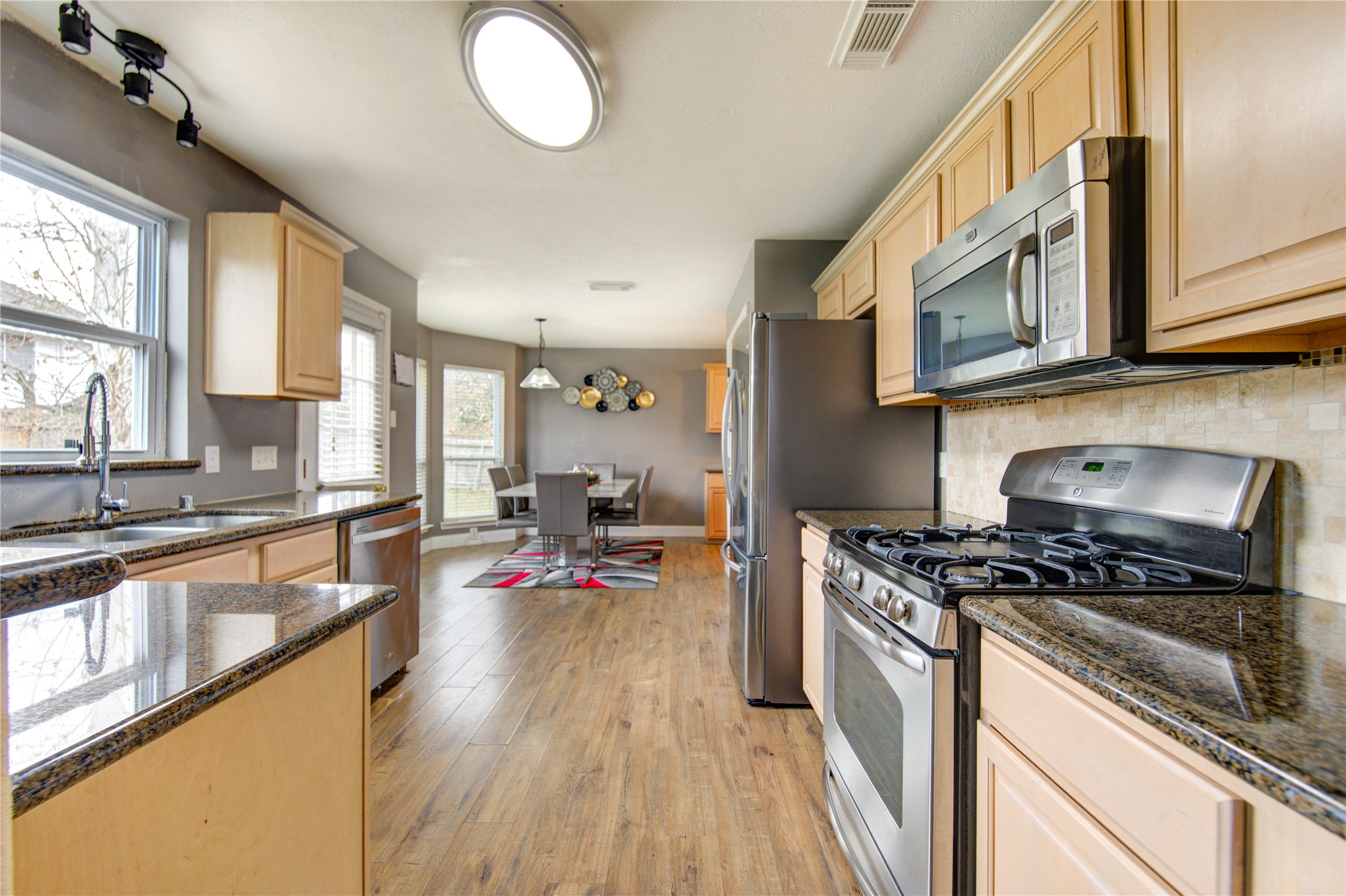 14902 Englebrook Drive Houston, TX 77095 - Photo 22 of 50 a kitchen with stainless steel appliances granite countertop a stove a sink dishwasher and cabinets with wooden floor