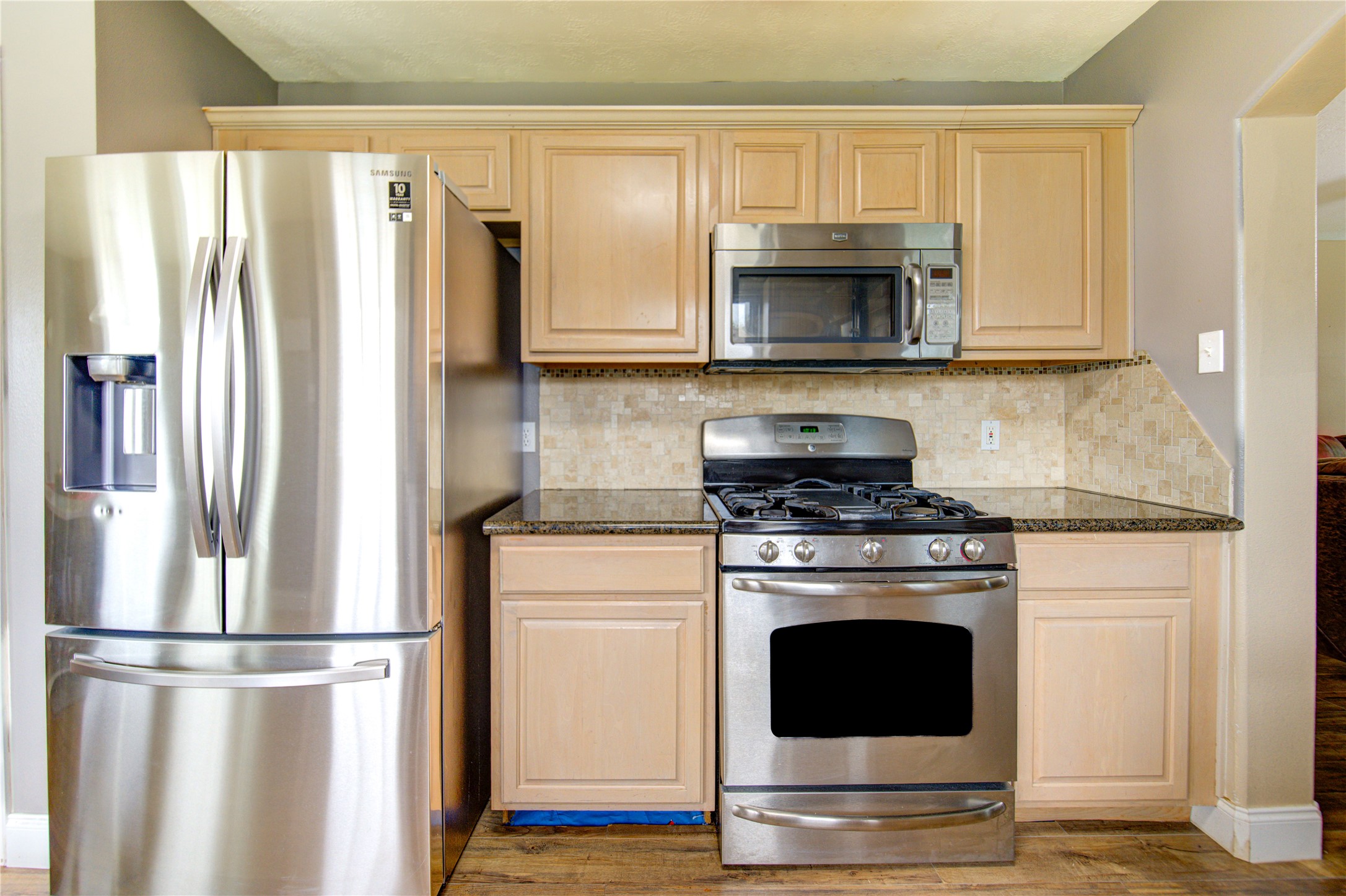 14902 Englebrook Drive Houston, TX 77095 - Photo 23 of 50 a kitchen with granite countertop a refrigerator stove and white cabinets