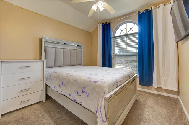 a living room with furniture a flat screen tv and kitchen view