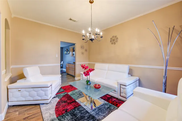 a living room with furniture and a chandelier