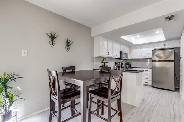 a kitchen with stainless steel appliances kitchen island a table and chairs in it