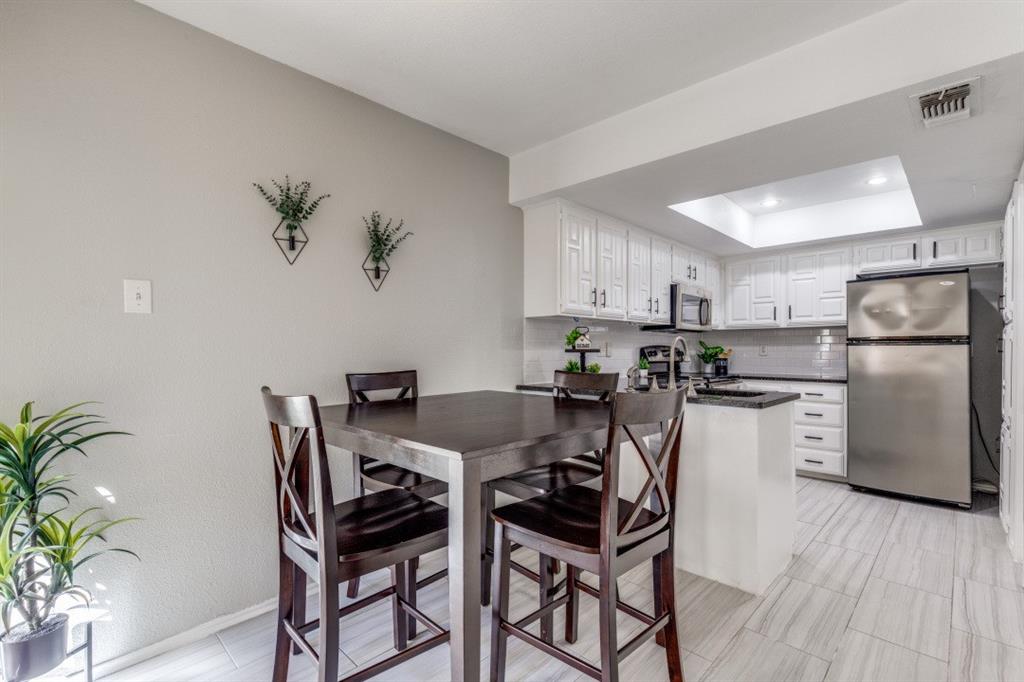 14151 Montfort Drive, Unit 345 Dallas, TX 75254 - Photo 11 of 31 a kitchen with stainless steel appliances kitchen island a table and chairs in it