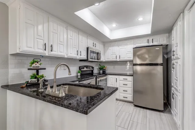 a kitchen with stainless steel appliances granite countertop a refrigerator sink and cabinets