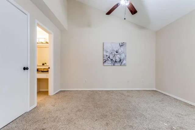 an empty room with a window and a ceiling fan