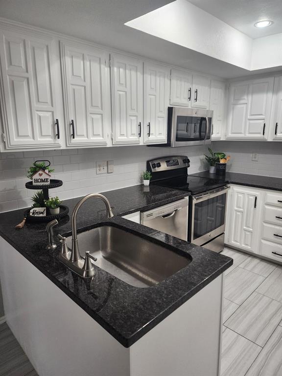 14151 Montfort Drive, Unit 345 Dallas, TX 75254 - Photo 10 of 31 a kitchen with stainless steel appliances granite countertop a sink a stove and white cabinets
