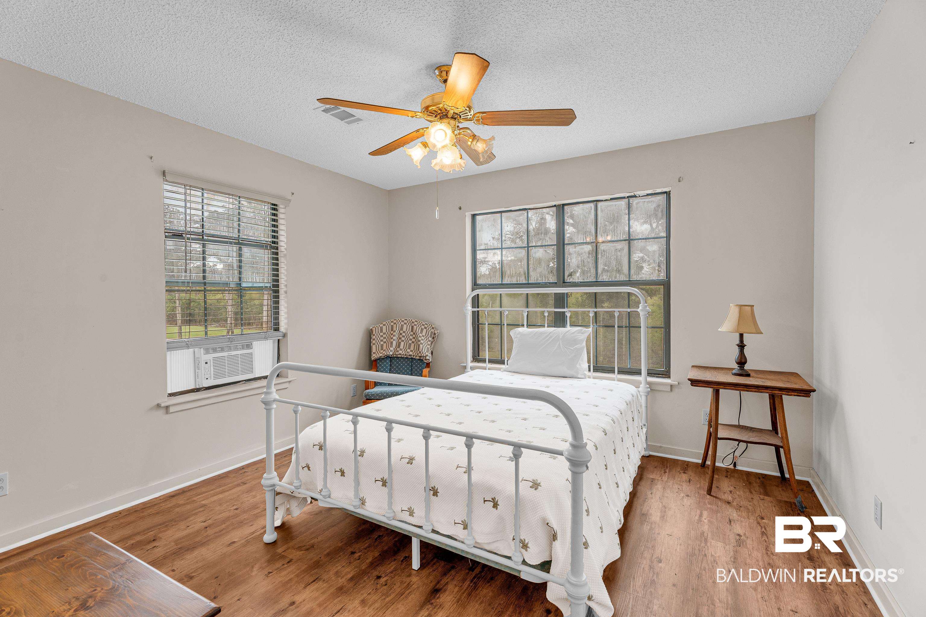 8317 Bryant's Lndg Road Stockton, AL 36579 - Photo 18 of 28 Bedroom with multiple windows, light wood finished floors, a textured ceiling, and ceiling fan