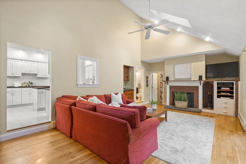 9 Deepwoods Drive Natick, MA 01760 - Photo 12 of 31 a living room with furniture a fireplace and kitchen view