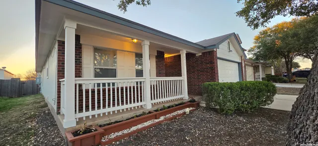 a porch with a bench next to a yard