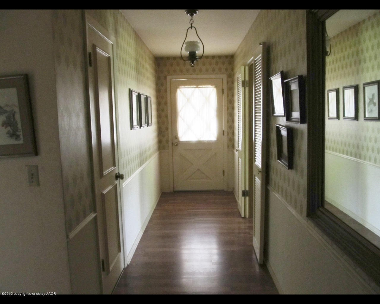 6707 Elmhurst Road Amarillo, TX 79106 - Photo 3 of 21 a view of a hallway with wooden floor and staircase