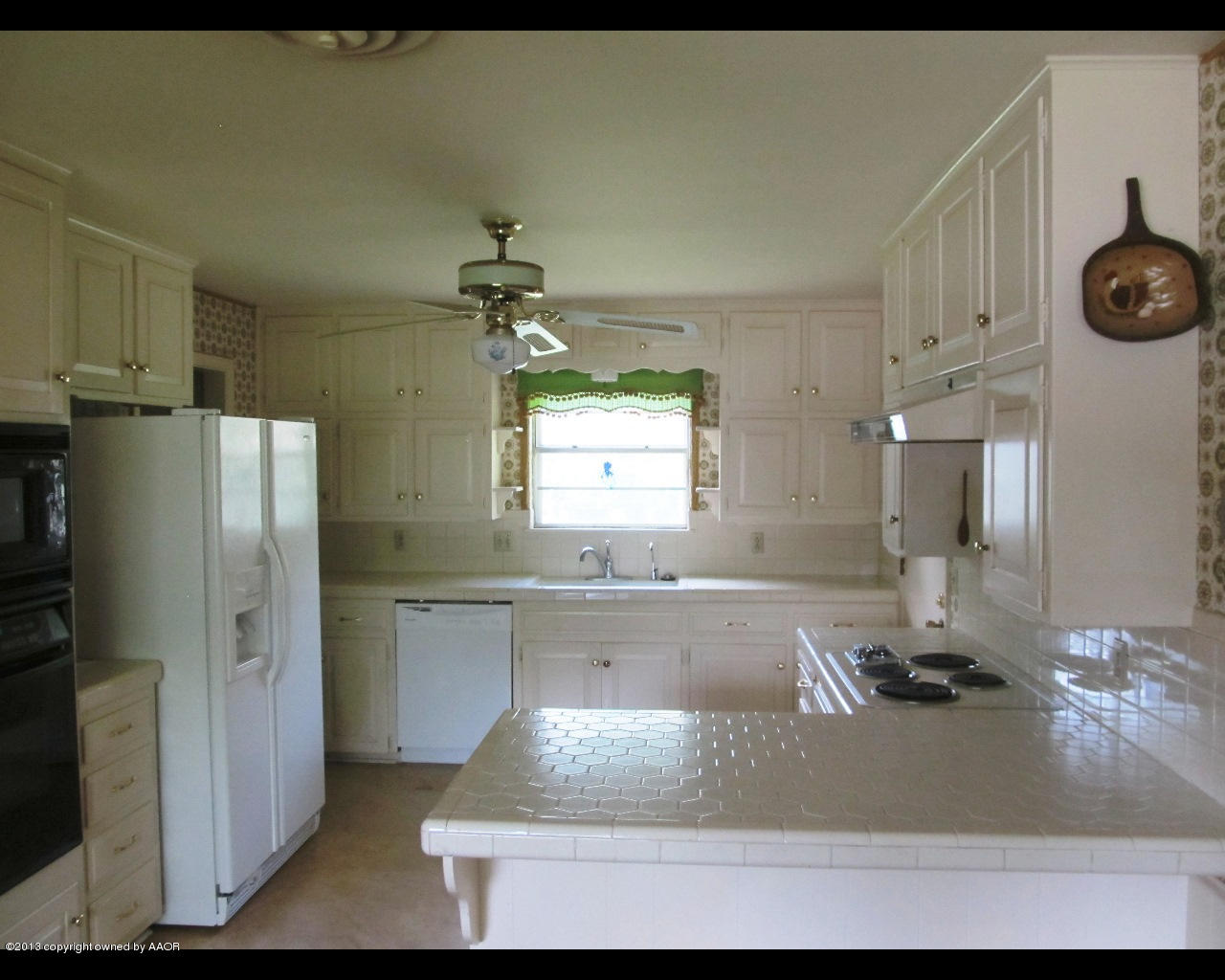 6707 Elmhurst Road Amarillo, TX 79106 - Photo 6 of 21 a kitchen with a refrigerator and a sink