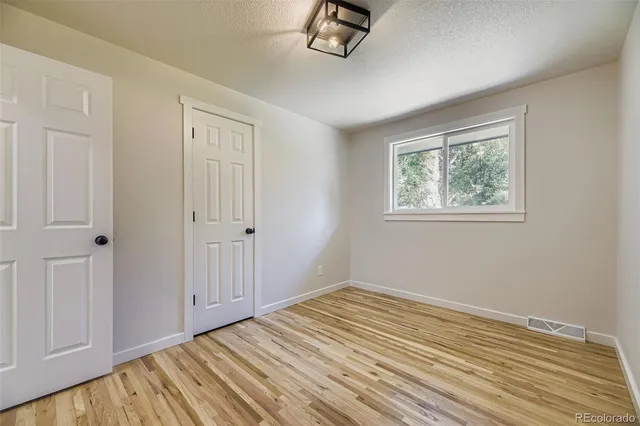 a view of empty room with wooden floor