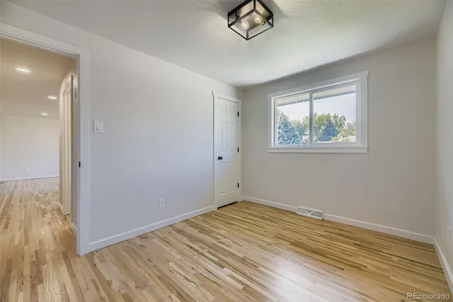 a view of empty room with wooden floor