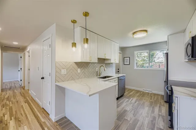 a kitchen with a sink stove and wooden floor
