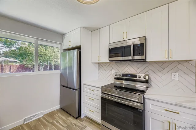 a kitchen with stainless steel appliances a stove microwave and refrigerator