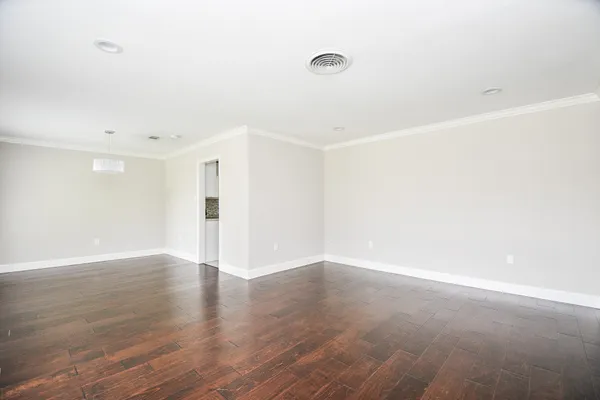 a view of an empty room with wooden floor