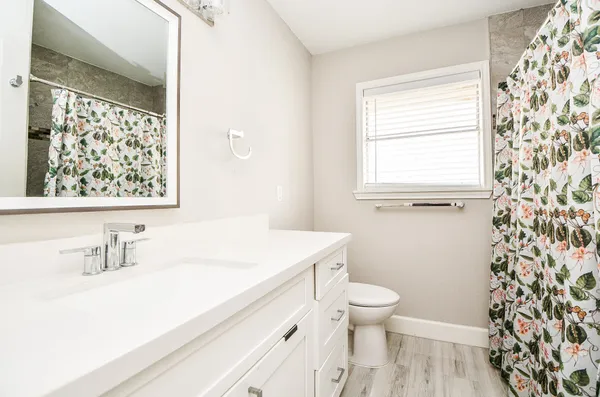 a bathroom with a sink a toilet and a window