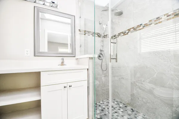a bathroom with a shower sink and mirror